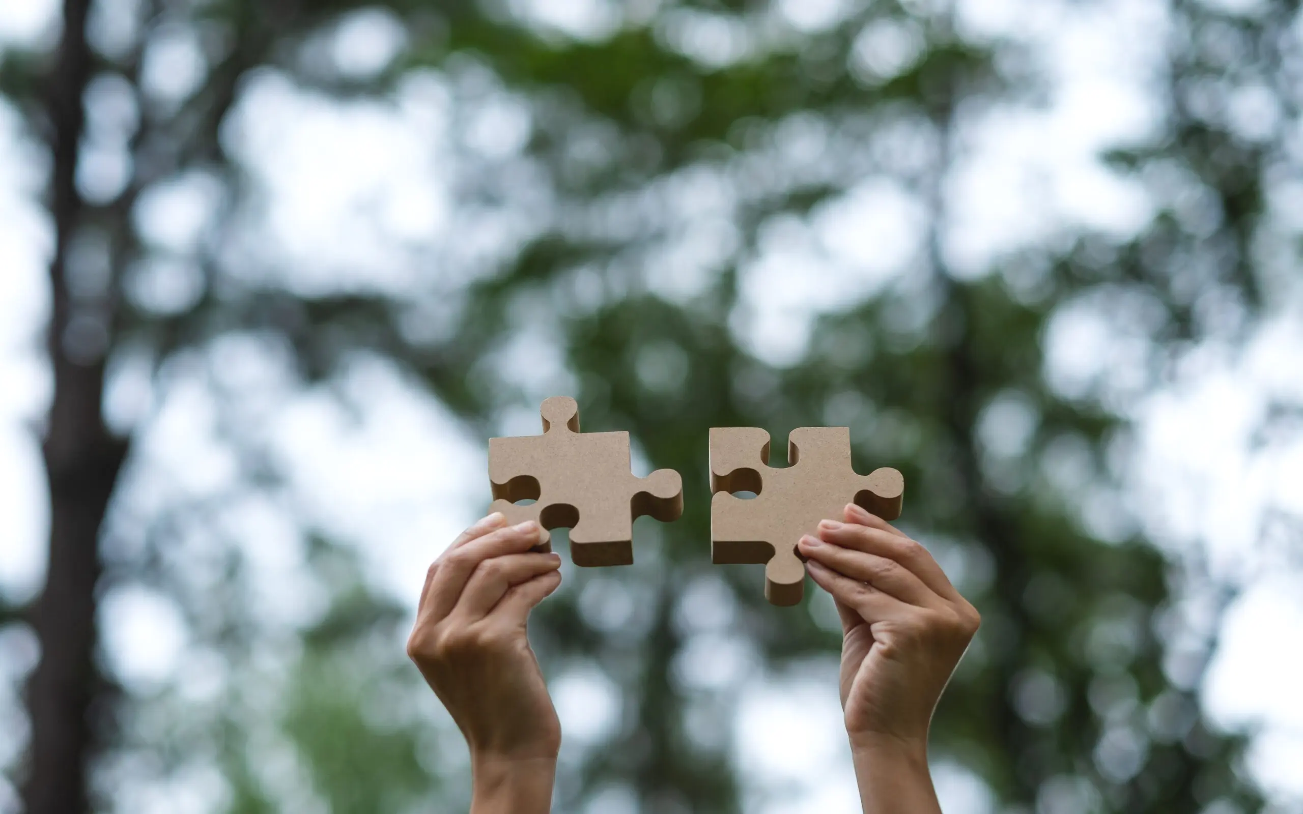 A woman holding up puzzle pieces